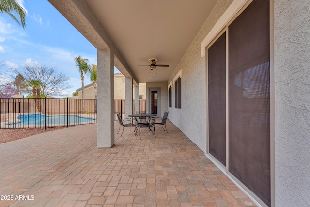 view of patio with outdoor dining space, a fenced backyard, a fenced in pool, and ceiling fan