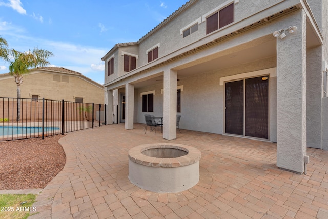 view of patio / terrace with fence, a fenced in pool, and an outdoor fire pit