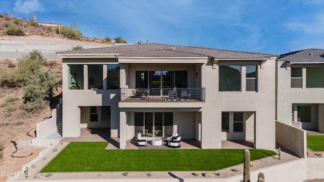 back of property featuring an outdoor living space, a balcony, a yard, and a patio