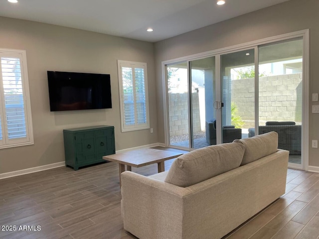 living room featuring recessed lighting, a healthy amount of sunlight, and wood tiled floor