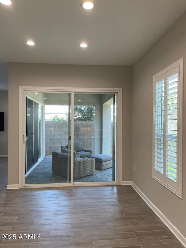 unfurnished room with plenty of natural light, recessed lighting, baseboards, and wood finish floors