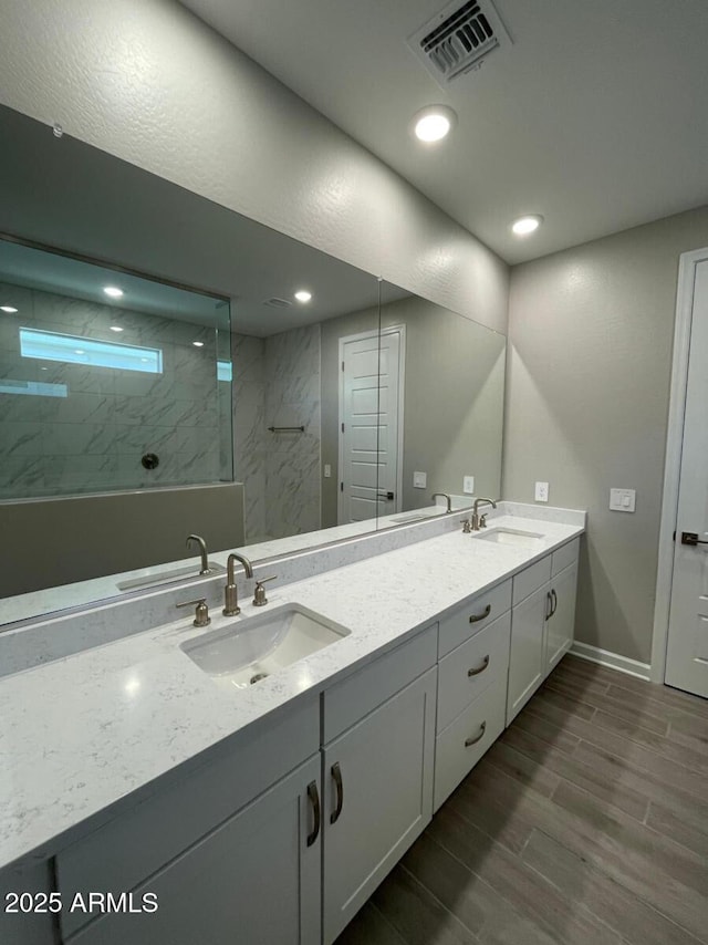 bathroom featuring wood tiled floor, visible vents, and a sink