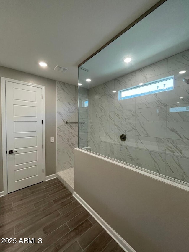 full bathroom featuring a marble finish shower, visible vents, baseboards, wood finish floors, and recessed lighting