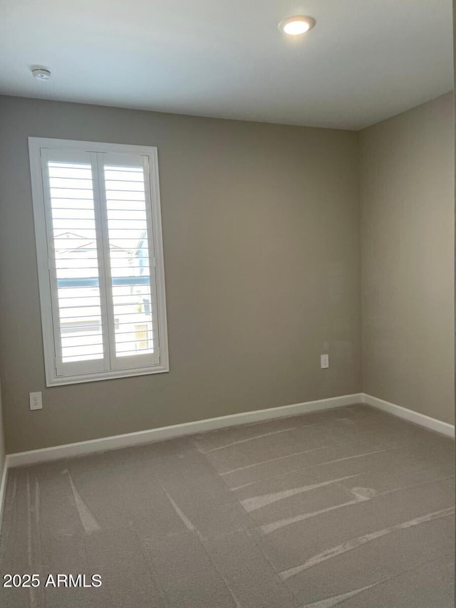 unfurnished room featuring baseboards and carpet floors