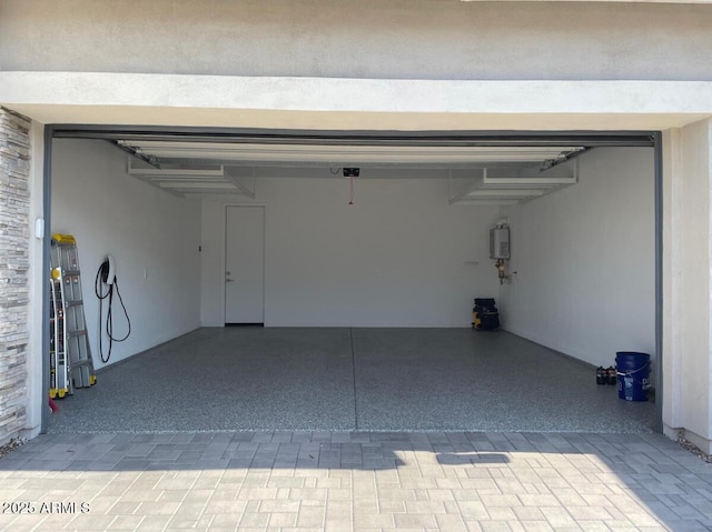 garage featuring a garage door opener and tankless water heater