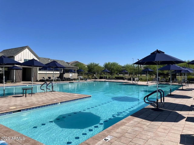 community pool with a patio and fence