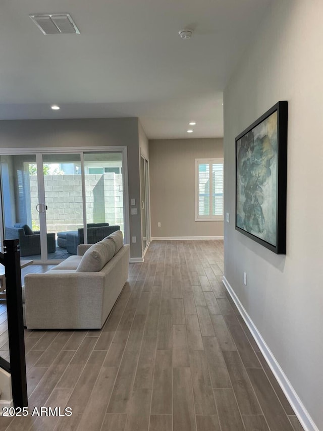 unfurnished living room with visible vents, recessed lighting, baseboards, and wood finished floors