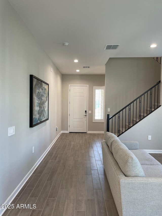 entrance foyer with visible vents, baseboards, dark wood-type flooring, and stairs