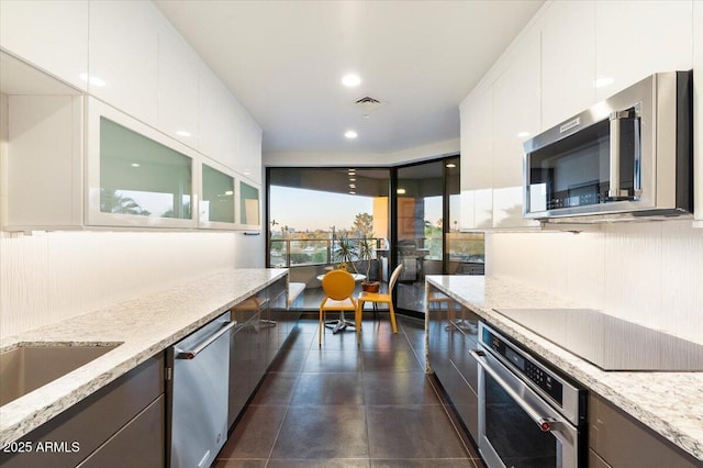 kitchen featuring white cabinetry, light stone countertops, visible vents, and stainless steel appliances