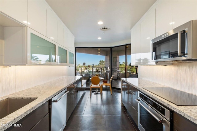 kitchen featuring visible vents, light stone countertops, appliances with stainless steel finishes, and white cabinets