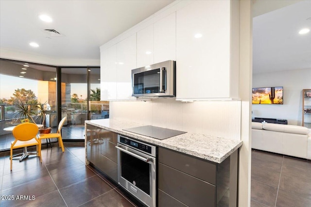 kitchen featuring modern cabinets, dark tile patterned flooring, appliances with stainless steel finishes, and white cabinets