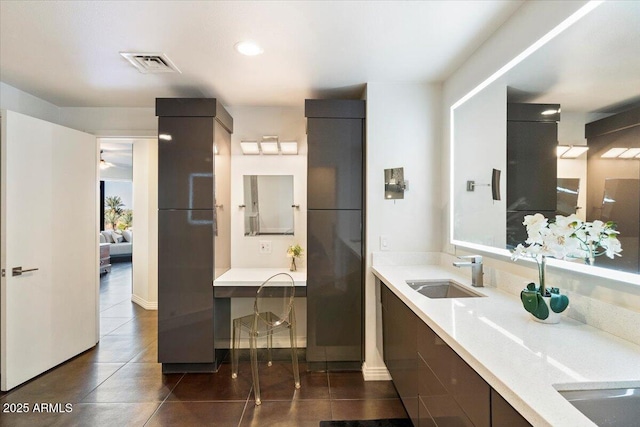 bathroom featuring visible vents, double vanity, a sink, ensuite bathroom, and tile patterned floors