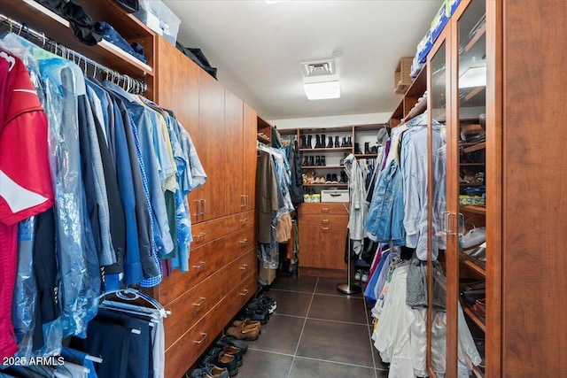 walk in closet with visible vents and dark tile patterned flooring