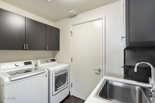 laundry area with cabinet space, washer and dryer, and a sink