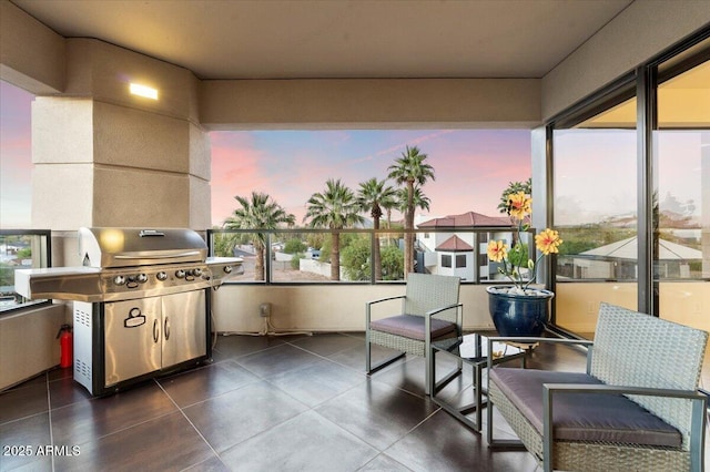 patio terrace at dusk featuring a grill and a balcony