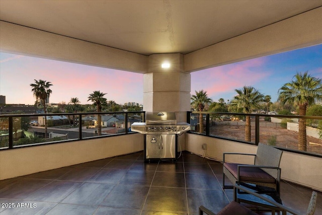 balcony at dusk featuring a grill