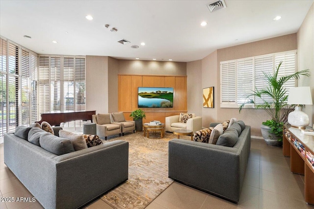 living room with a wealth of natural light, visible vents, and recessed lighting