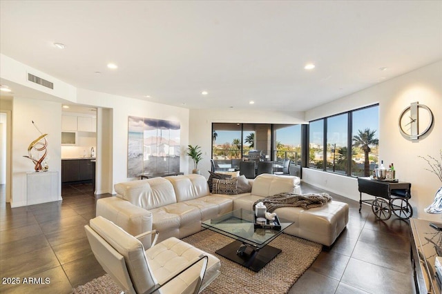 living area with recessed lighting, visible vents, and baseboards