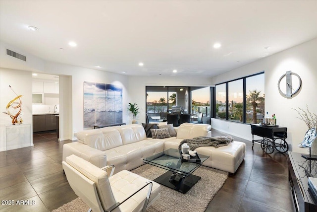 living area featuring recessed lighting, visible vents, and baseboards