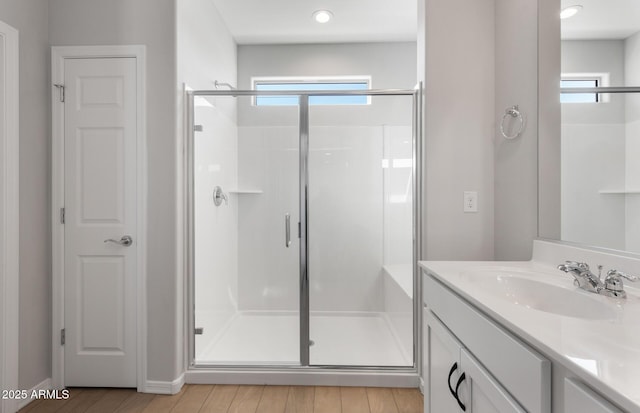 bathroom with an enclosed shower, vanity, and wood-type flooring