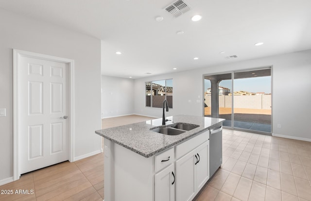 kitchen featuring sink, light stone counters, dishwasher, an island with sink, and white cabinets