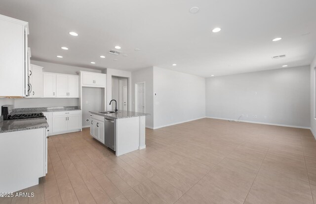 kitchen featuring white cabinetry, stone countertops, sink, and a center island with sink