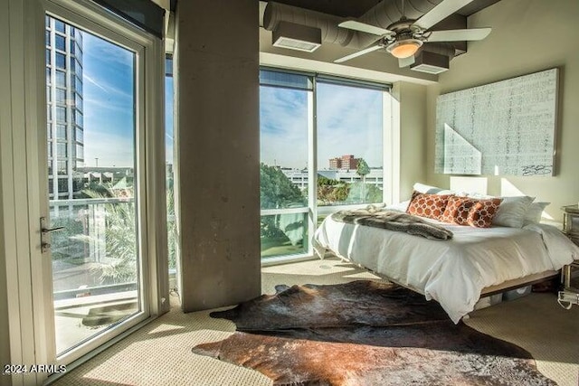 carpeted bedroom featuring multiple windows and ceiling fan