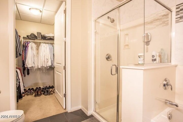 bathroom featuring tile patterned floors, a drop ceiling, and a shower with shower door