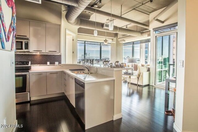 1 E Lexington Ave Unit 410, Phoenix, AZ 85012 - kitchen with appliances with stainless steel finishes, a peninsula, dark wood-style flooring, and a sink