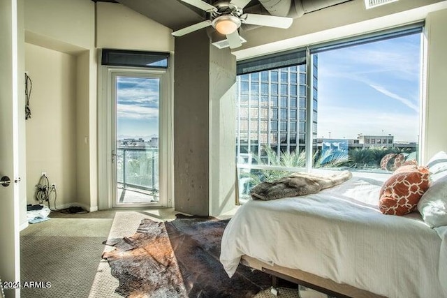 carpeted bedroom with vaulted ceiling, ceiling fan, and multiple windows