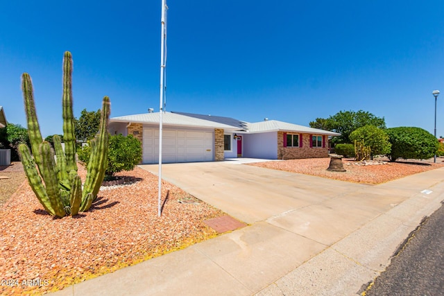 ranch-style home featuring cooling unit and a garage