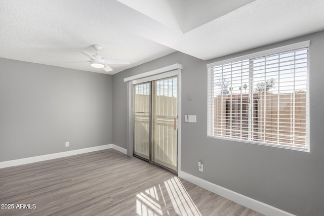 unfurnished room featuring ceiling fan, wood-type flooring, and a textured ceiling