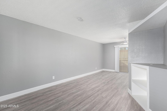 unfurnished living room featuring light wood-type flooring and a textured ceiling