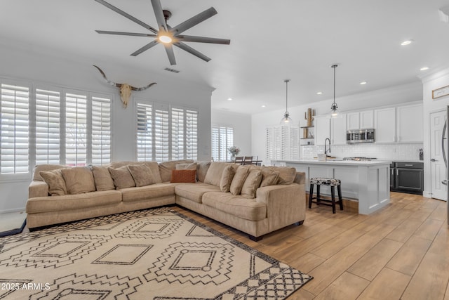 living area featuring light wood-type flooring, ceiling fan, recessed lighting, and visible vents