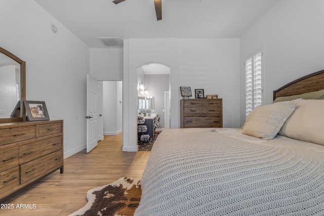 bedroom with visible vents, baseboards, arched walkways, ceiling fan, and light wood-type flooring