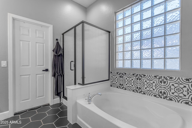 full bathroom with a wealth of natural light, tile patterned floors, a shower stall, and a garden tub