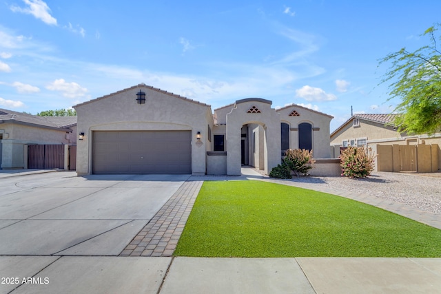 mediterranean / spanish-style house featuring concrete driveway, an attached garage, fence, and stucco siding