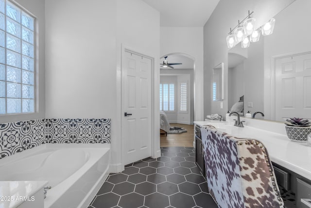 bathroom featuring ensuite bathroom, ceiling fan, a bath, vanity, and tile patterned floors