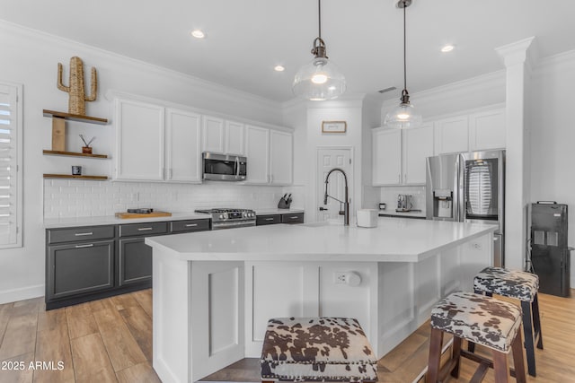 kitchen featuring tasteful backsplash, open shelves, a sink, ornamental molding, and stainless steel appliances