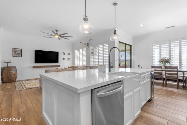 kitchen with crown molding, stainless steel dishwasher, ceiling fan, visible vents, and a sink