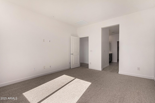 unfurnished bedroom featuring ensuite bathroom and carpet floors