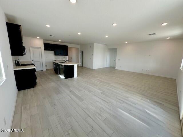 kitchen with an island with sink and light hardwood / wood-style flooring