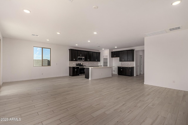 unfurnished living room with sink and light wood-type flooring