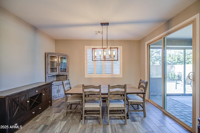 dining space featuring visible vents, plenty of natural light, and wood finished floors