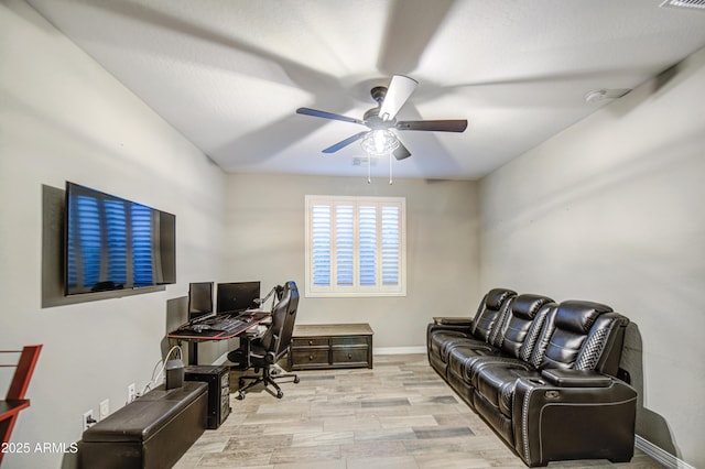 office area with ceiling fan, baseboards, and light wood-type flooring