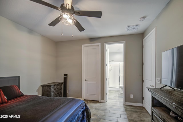 bedroom with wood tiled floor, ceiling fan, visible vents, baseboards, and ensuite bath