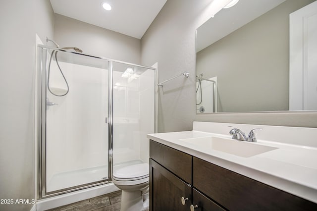full bathroom with vanity, a shower stall, toilet, and wood finished floors