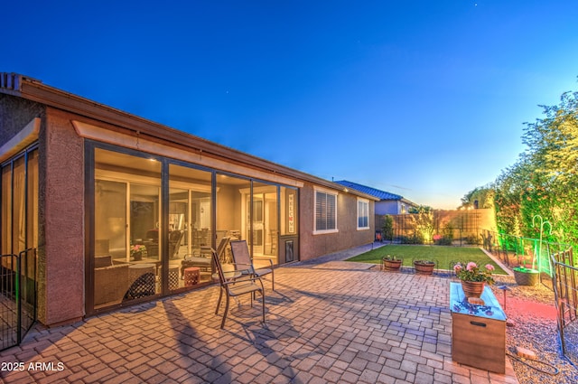 patio terrace at dusk with a fenced backyard
