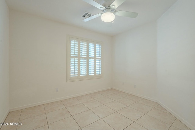 tiled spare room with ceiling fan