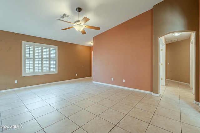 spare room with ceiling fan and light tile patterned floors